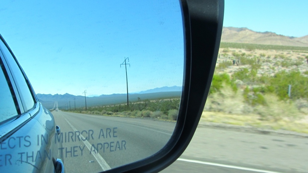 Picture of a side mirror of a car with the phase, "Objects in Mirror are Closer than They Appear"