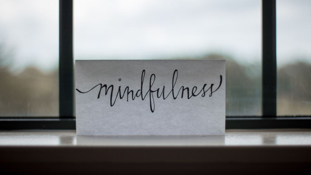 A piece of paper next to a window with "Mindfulness" written on the piece of paper
