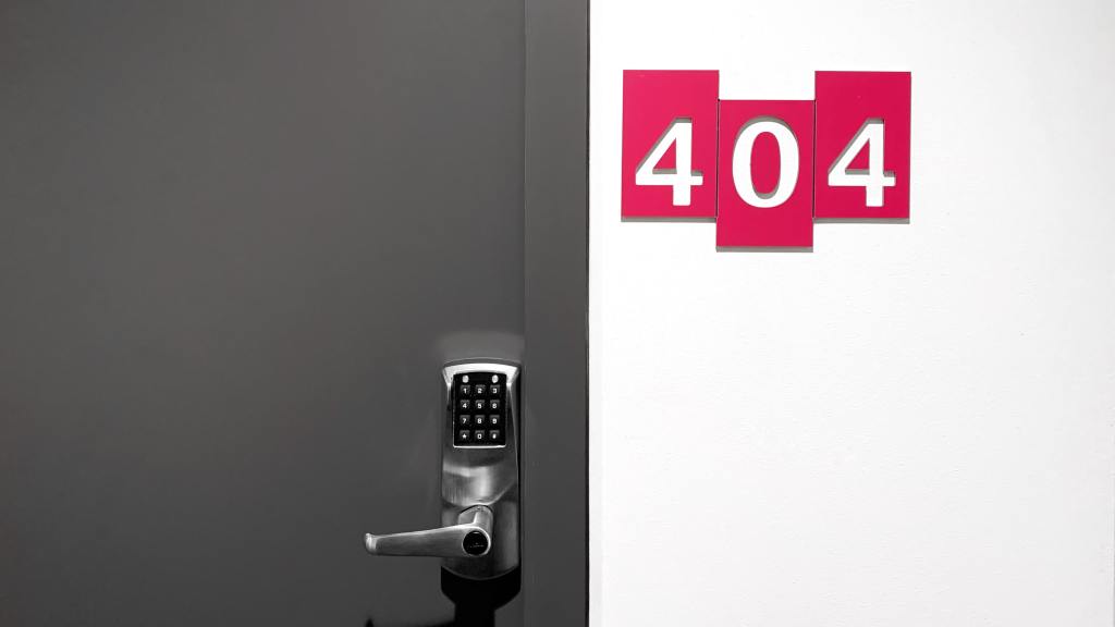 A picture of a closed door with the numbers 404 on the wall to the right of the door handle